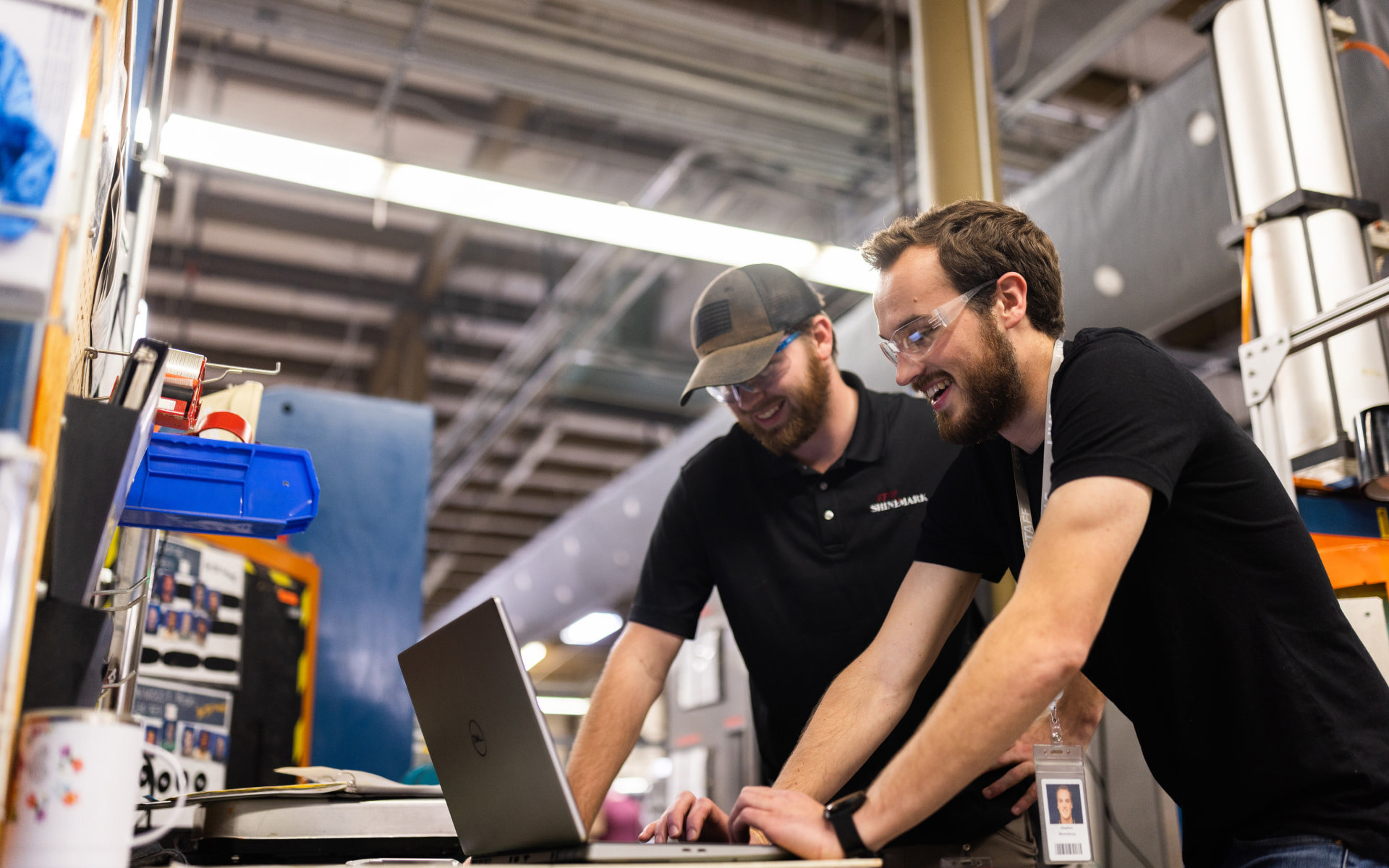 Two employees gathered around a laptop