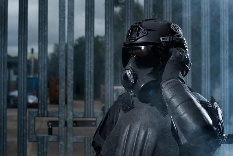 Police officer wearing riot vest, helmet and respirator