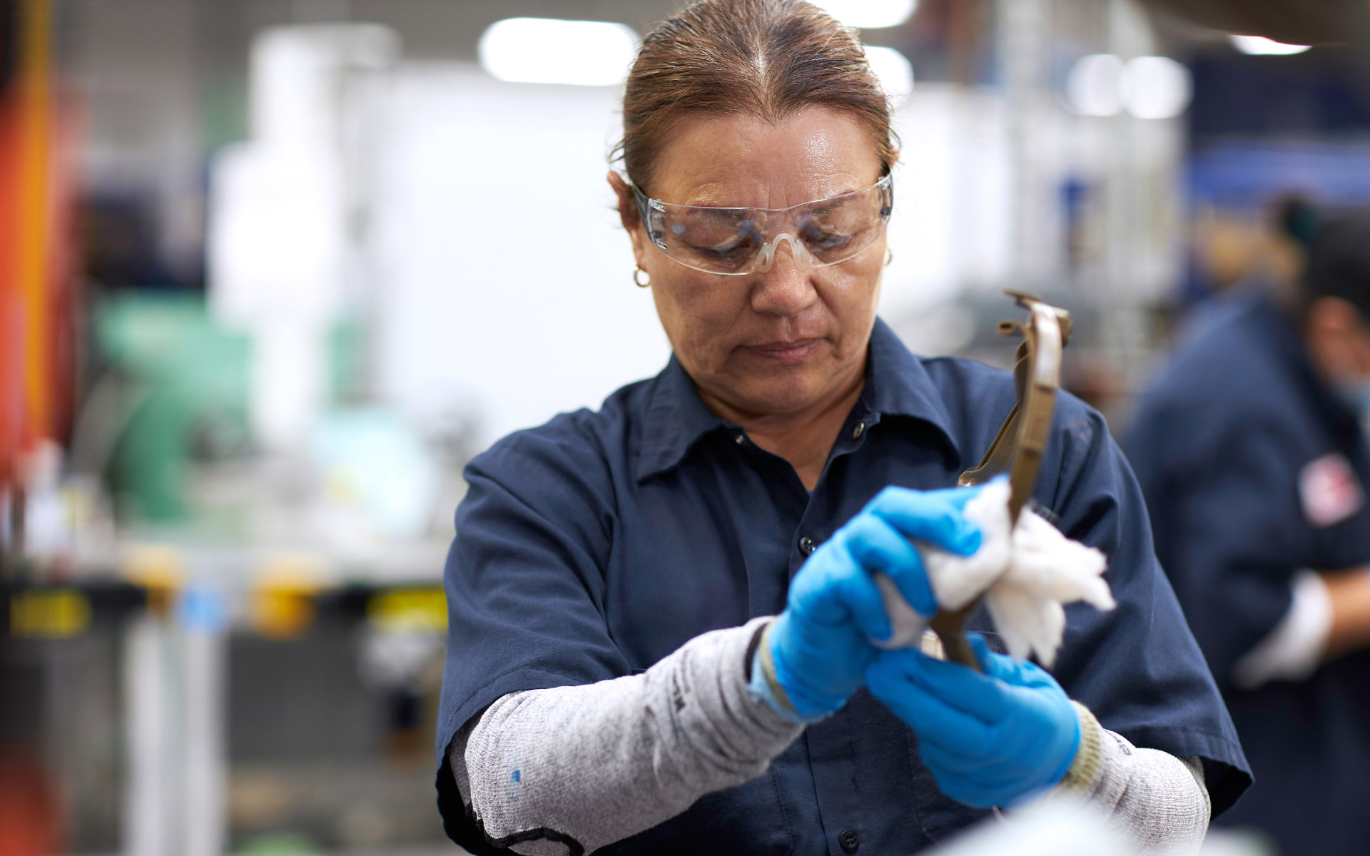 Employee quality checking a helmet part