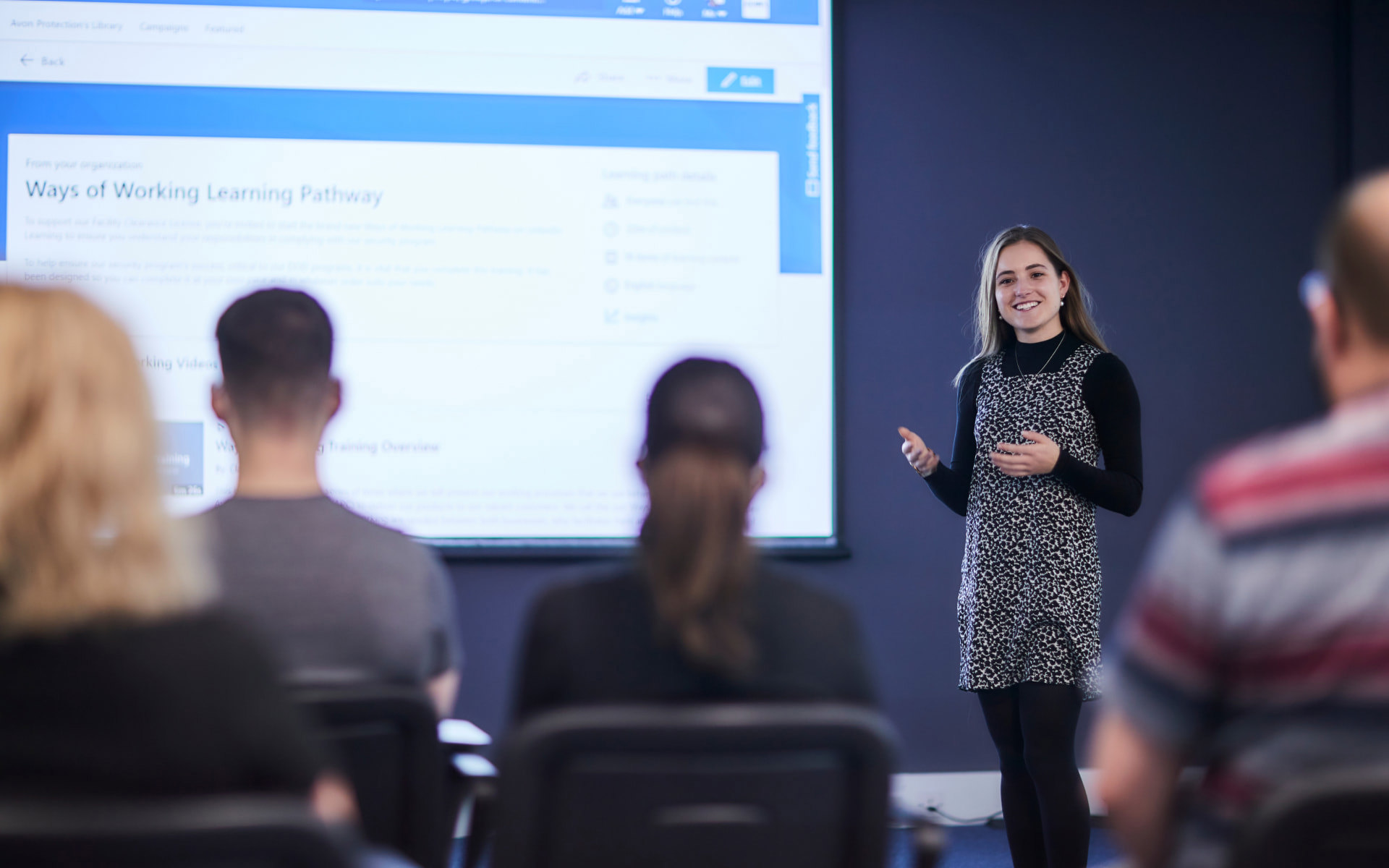 Employee presenting in front of a room of colleagues 