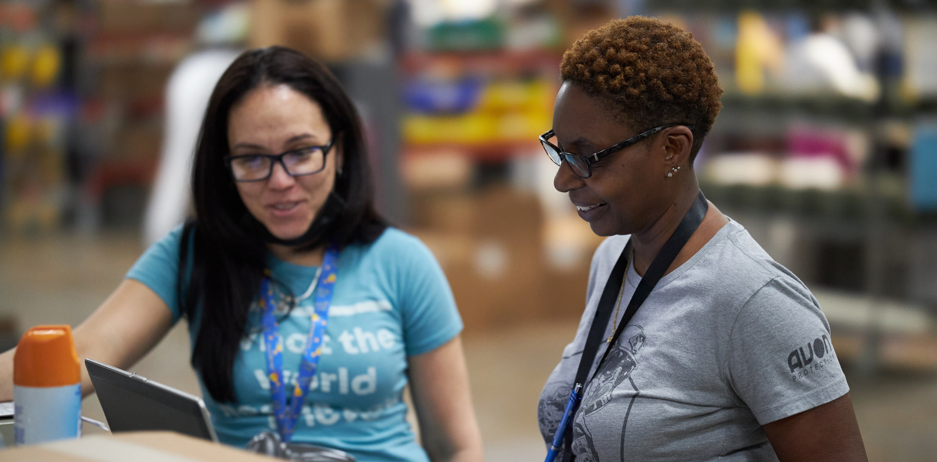 Two employees gathered around a laptop